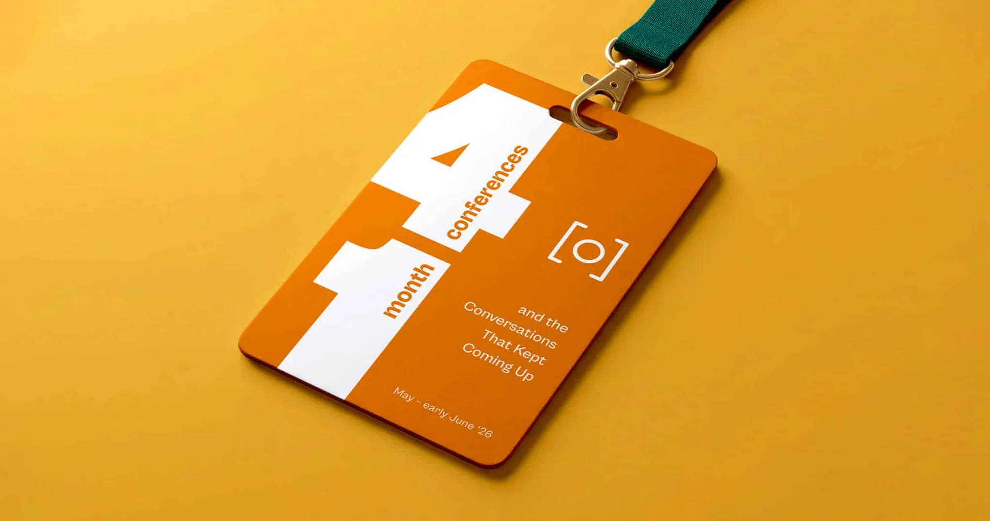 An orange conference badge on a green lanyard reading 4 conferences, 1 month, and the conversations that kept coming up